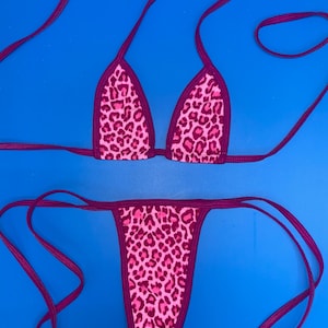 Op de afbeelding: Een roze en paarse bikini met luipaardprint en dunne bandjes. De bikini top is van het driehoekige type en de onderkant is van het cheeky type.