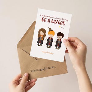 May include: A greeting card with the text "In A World Where You Can Be Anything BE A WIZARD" and three cartoon wizards. The card is held in a brown envelope. The words "Happy Birthday!" are written on the card.
