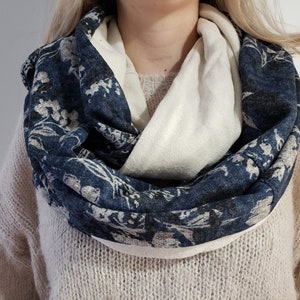 May include: A blue and white infinity scarf with a floral pattern. The scarf is made of a soft, comfortable fabric and is ideal for keeping warm in the winter.