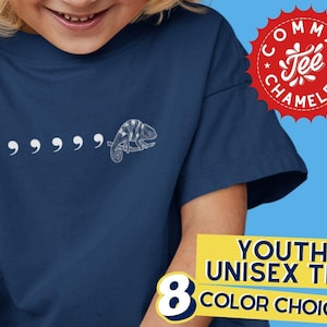 May include: A navy blue youth unisex t-shirt with a white chameleon graphic and five white commas. The shirt has the text "Comma Tee Chameleon" in a red circle with white stars.