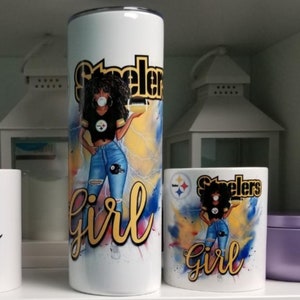 K&ouml;nnte beinhalten: Zwei wei&szlig;e Becher mit einem schwarzen und gelben Steelers-Logo und einem Cartoon-Bild einer Frau, die ein Steelers-Trikot und Jeans tr&auml;gt. Der Text "Steelers Girl" ist in Gold auf beiden Bechern geschrieben.