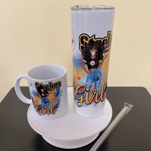 K&ouml;nnte beinhalten: Eine wei&szlig;e Keramiktasse und ein wei&szlig;er Edelstahlbecher mit einem schwarzen und gelben Steelers-Logo und einem Cartoon-Bild einer Frau, die ein Steelers-Trikot und Jeans tr&auml;gt. Der Text "Steelers Girl" ist auf beiden Artikeln aufgedruckt.
