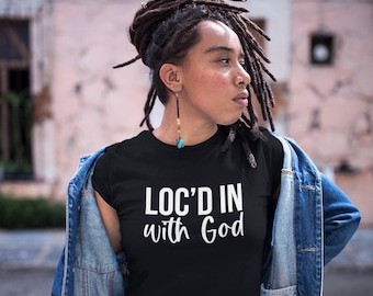 May include: A black t-shirt with the text "LOC'D IN with God" in white lettering.