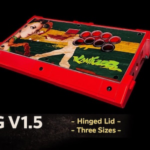 May include: Red arcade game controller with a colorful graphic design on the top panel. The panel features a woman's image, a figure, and the word "Kontroller" in green. The controller has eight red buttons and a joystick.