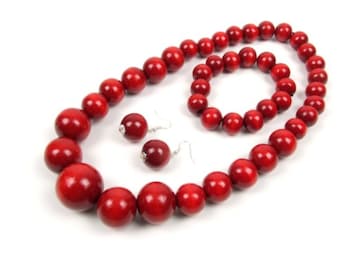 May include: A red wooden bead necklace, bracelet, and earrings set. The necklace and bracelet are made of large, round beads. The earrings are small and have a simple design.