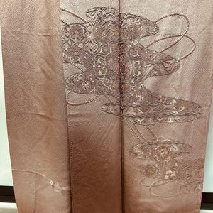 K&ouml;nnte beinhalten: Ein braunes Seidenkimono mit traditionellem japanischem Design. Das Design zeigt ein stilisiertes Blumenmuster in Gold- und Silberfaden.