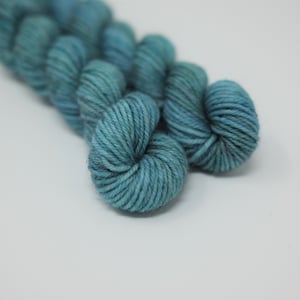 May include: Two skeins of teal blue yarn, wound into balls.