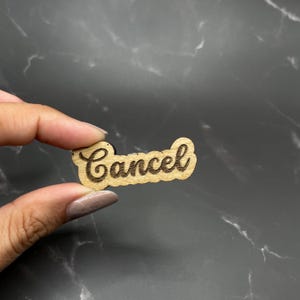 May include: A wooden sign with the word "Cancel" written in cursive.