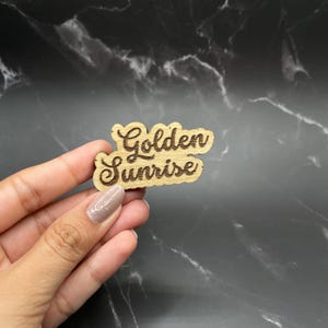 May include: Wooden sign with the text "Golden Sunrise" in a cursive font.