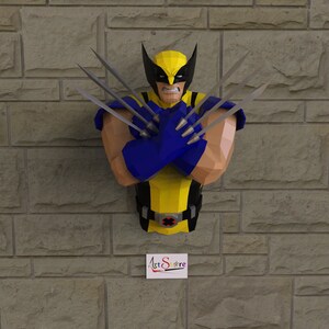 Puede incluir: Una escultura de origami de Wolverine, un superhéroe de Marvel Comics, con sus garras extendidas. La escultura está hecha de papel amarillo y azul y está montada en una pared de ladrillo.