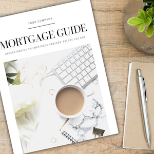 May include: A white guide with the text "MORTGAGE GUIDE" and "UNDERSTANDING THE MORTGAGE PROCESS. BEFORE YOU BUY" in black text. The guide is on a wooden table with a white keyboard, a cup of coffee, a notebook, a pen, and white flowers.