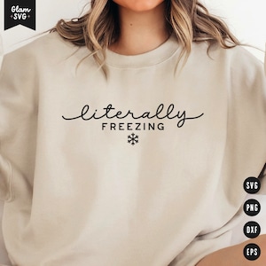 May include: A beige sweatshirt with the text "literally freezing" in black cursive font and a snowflake symbol.
