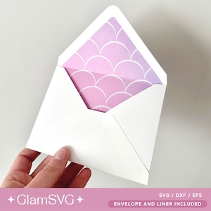 May include: A white envelope with a pink and purple ombre liner featuring a white scale pattern. The text "ENVELOPE AND LINER INCLUDED" is printed on the bottom of the envelope.