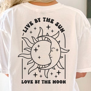 Könnte beinhalten: Weißes T-Shirt mit einer schwarzen Grafik einer Sonne und eines Mondes mit dem Text "Live by the sun, love by the moon".