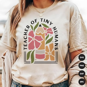 Peut inclure: Un t-shirt beige avec le texte "Teacher of Tiny Humans" dans un cadre noir. Le texte est entouré d'un crayon et d'un motif floral en rose, jaune et vert.
