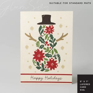 Puede incluir: Tarjeta navide&ntilde;a color crema con un dise&ntilde;o de mu&ntilde;eco de nieve hecho de flores de pascua rojas, hojas verdes y un sombrero de copa marr&oacute;n y brazos de ramitas. La tarjeta dice "Happy Holidays" en una pancarta roja. La tarjeta mide 12,7 cm x 17,8 cm.