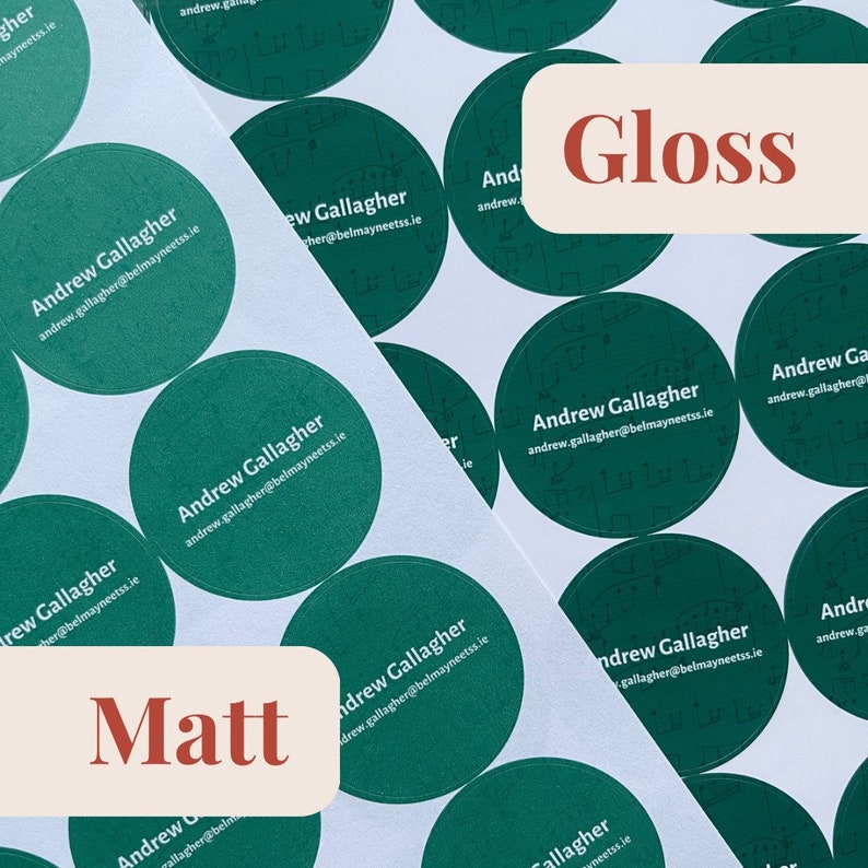 May include: Close-up of a stack of round green stickers with the text "Andrew Gallagher" and an email address. The stickers are on a white surface. The word "Gloss" is written in red on a white rectangle.