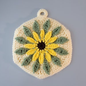 Crocheted sunflower kitchen hot pad set. Double layer pot holders with textured sunflower front and top ring for hanging. Set of 2.