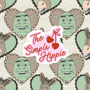May include: A repeating pattern featuring cartoon images of Shrek and a donkey, set against a textured background. A pink sticker with the words "The Simple Hippie" and cherry illustrations is overlaid on the pattern.