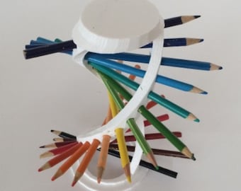May include: A white plastic pencil holder shaped like a spiral. The holder is filled with colored pencils, including red, orange, yellow, green, blue, and black.