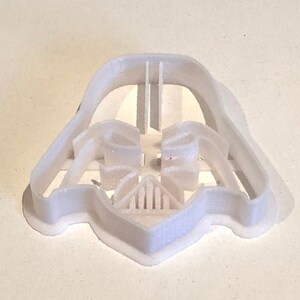 May include: White plastic cookie cutter shaped like Darth Vader's helmet from Star Wars.