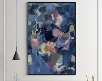 May include: Abstract painting in shades of blue, pink, and white. The painting is framed in black and hangs on a white wall above a wooden table with a cactus, plants, and decorative items.