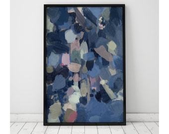 May include: Abstract art print in a black frame. The artwork features a blend of blue, gray, and pink brushstrokes. The painting is displayed against a white wall and rests on a white wooden floor, creating a modern aesthetic.