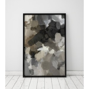 May include: Abstract painting in shades of gray, brown, and black. The painting is framed in a black frame and is hanging on a white wall.