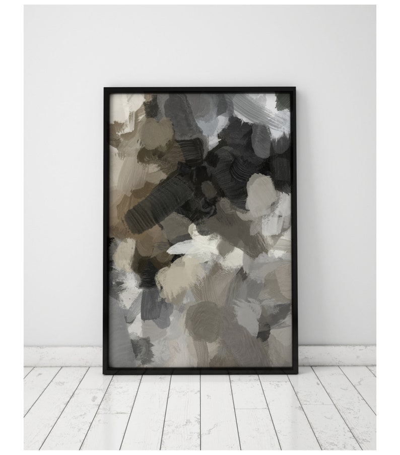 May include: Abstract painting in shades of gray, brown, and black. The painting is framed in a black frame and is hanging on a white wall.