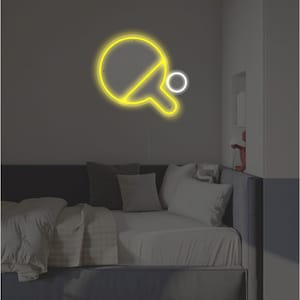 May include: A yellow neon sign of a ping pong paddle and ball on a dark wall above a bed with white bedding.