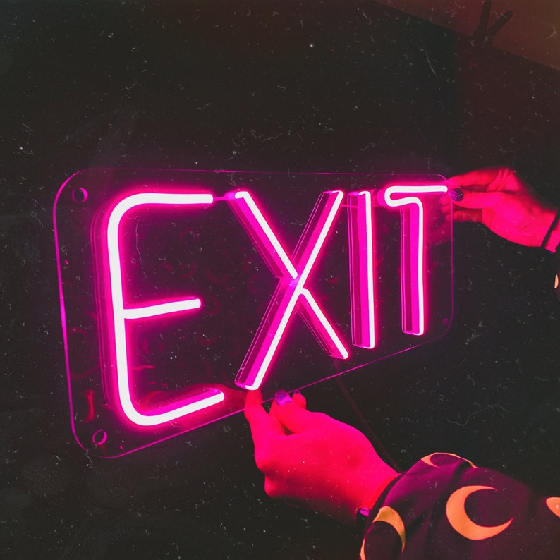May include: A pink neon sign with the word "EXIT" in a clear acrylic frame.