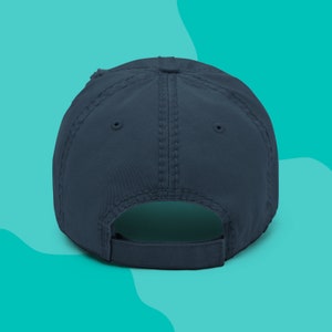 Back side of a navy distressed dad hat that is embroidered with the words Mental Health Matters.