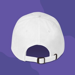 The back of a white dad hat to show the adjustable strap.