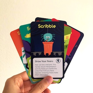 Illustrated card deck displaying drawing and journaling activities for mental health. Card in center shows activity description.