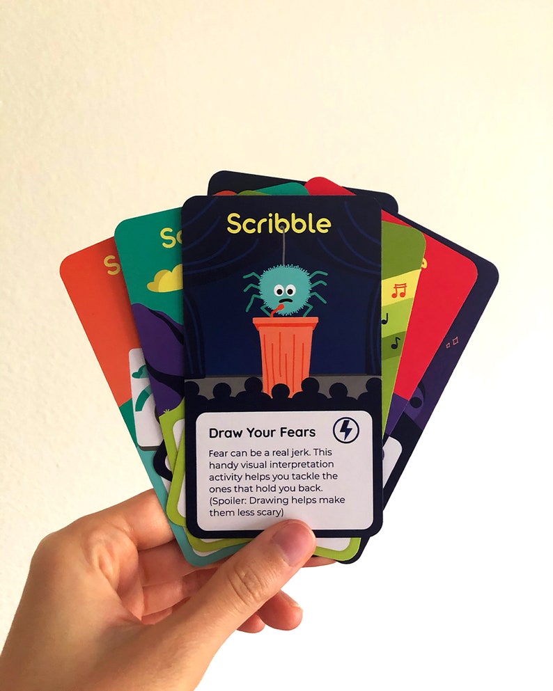 Illustrated card deck displaying drawing and journaling activities for mental health. Card in center shows activity description.