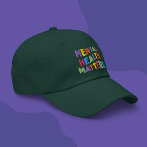 Green dad hat with Mental Health Matters embroidered in colorful letters.