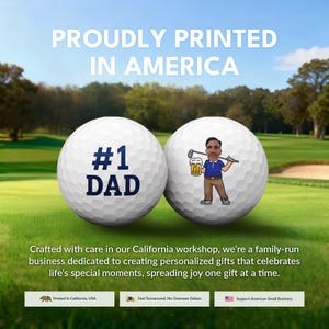 The image is an advertisement for a golf-themed gift, featuring two golf balls with personalized messages. The text on the golf balls reads "Proudly Printed in America" and "#1 DAD", indicating the golf balls are personalized gifts for a father. The advertisement also mentions that the gifts are created with care in California, and the company is a family-run business dedicated to creating personalized gifts for special moments.
