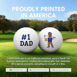The image is an advertisement for a golf-themed gift, featuring two golf balls with personalized messages. The text on the golf balls reads "Proudly Printed in America" and "#1 DAD", indicating the golf balls are personalized gifts for a father. The advertisement also mentions that the gifts are created with care in California, and the company is a family-run business dedicated to creating personalized gifts for special moments.