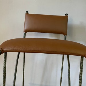 Antique wrought iron ornate bar stool. Newly reupholstered.  Gorgeous chair. Seat height 31”.