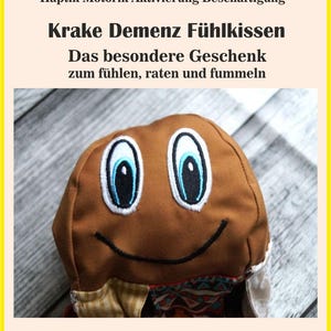 May include: A brown, plush octopus-shaped sensory pillow with embroidered blue and white eyes and a black smile. The pillow has the text "Krake Demenz Fühlkissen" and other German text.