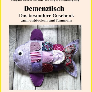 Peut inclure: Un poisson en peluche avec un corps floral violet et divers empiècements en tissu aux tons roses, rouges et à motifs. Le texte indique : Demenz Autismus Alzheimer Haptik Motorik Aktivierung Beschäftigung Demenzfisch Das besondere Geschenk zum entdecken und fummeln Beispielfild.
