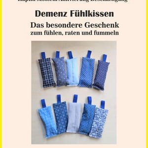 May include: Ten sensory pillows with blue fabric loops are displayed. The rectangular pillows have diverse blue patterns, such as checks, polka dots, and stripes. The image includes text: "Demenz Fühlkissen" and "Beispielbild".