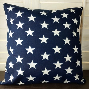 May include: A navy blue throw pillow with a white star pattern.