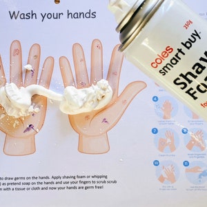 May include: A white poster with the words "Wash your hands" printed on it. Two cartoon hands are shown with white shaving cream on them. A can of Coles Smart Buy Shave Foam is shown in the upper right corner of the image.