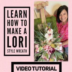 May include: Learn how to make a Lori style wreath. A video tutorial shows a wreath with pink and white flowers, green leaves, and a burlap bow with a pink ribbon.