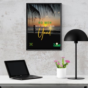 May include: Framed wall art featuring a sunset beach scene with palm trees. The artwork includes the text "NO WEH NUH BETTA DAN Yaad" in yellow and green, along with the Jamaican flag. A black desk lamp, laptop, and potted flowers are also visible.