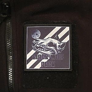 May include: Black and white patch with a wolf skull graphic and the text "Black Wolf Pack".