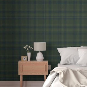 May include: A bedroom with a green plaid wallpaper, a bed with white bedding, a wooden nightstand with a lamp, and a wooden bench at the foot of the bed.