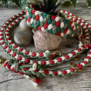 Può includere: Un set di collare e guinzaglio intrecciati per cani in rosso, bianco e verde. Il collare e il guinzaglio sono realizzati in un materiale spesso e resistente con finiture in metallo color oro. Il guinzaglio ha un'etichetta con il nome "ZUMA".