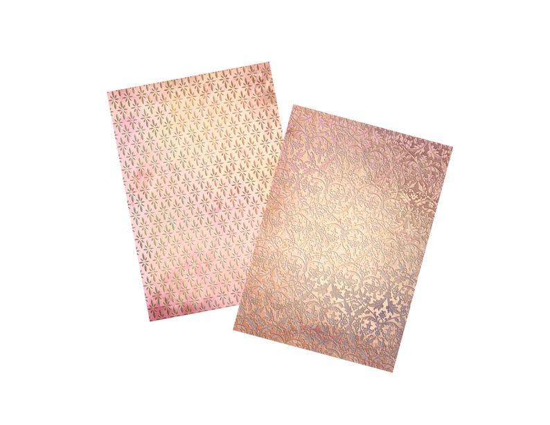 May include: Two sheets of decorative paper with a gold foil finish. The paper has a delicate floral pattern and a subtle pink and white ombre effect.
